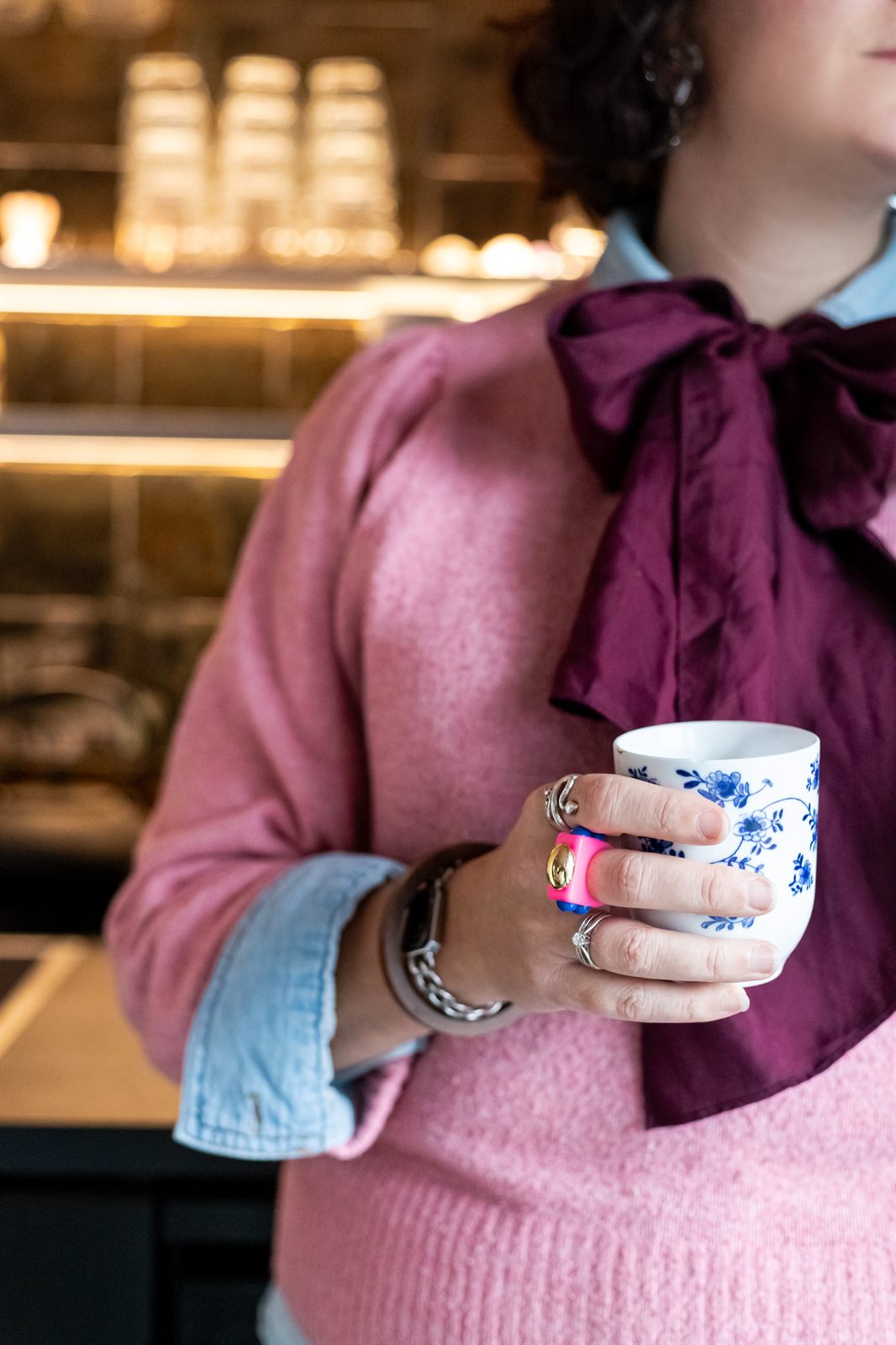 Elianne Alblas met een kop koffie in een café, detail van haar handen en het kopje